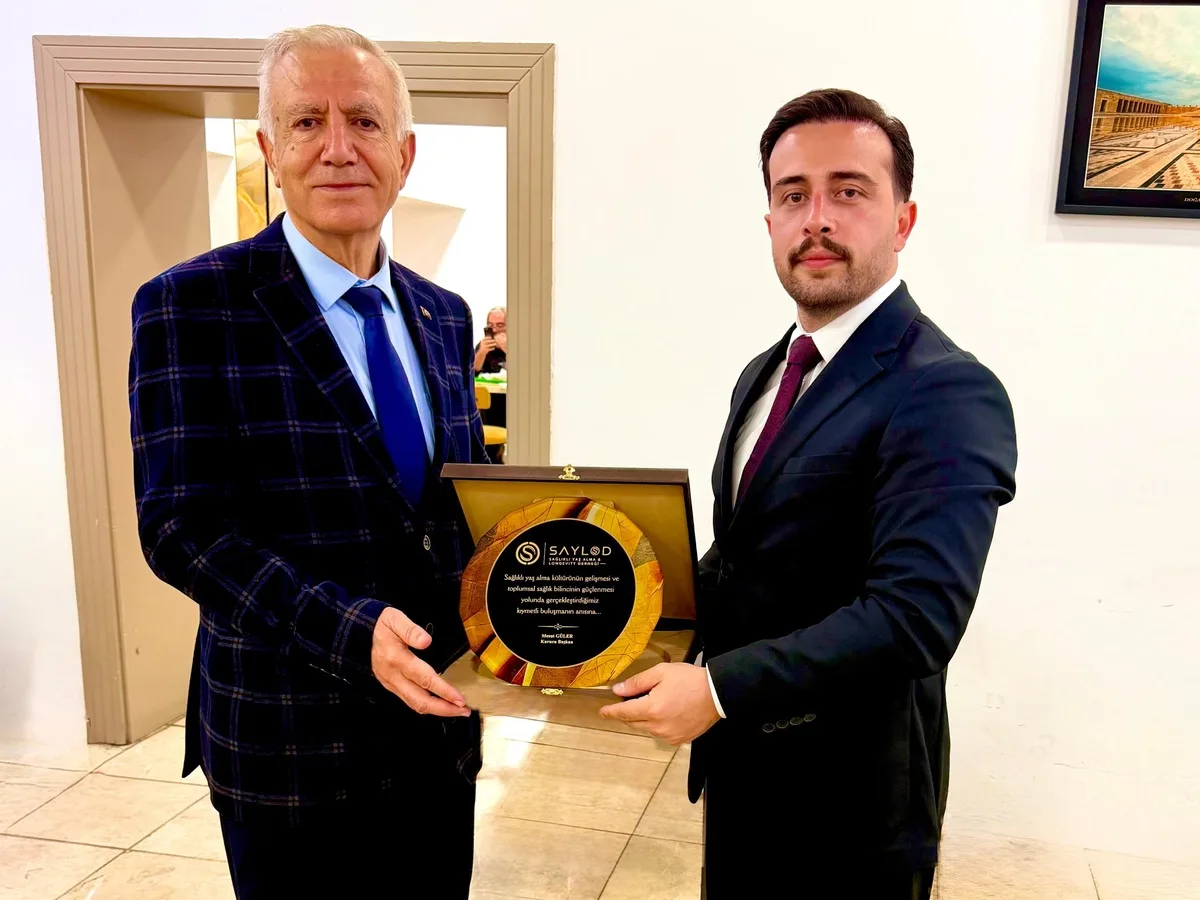 SAYLOD Genel Başkanı Mesut Güler, törene katılan konuğumuza plaket takdim ederken.