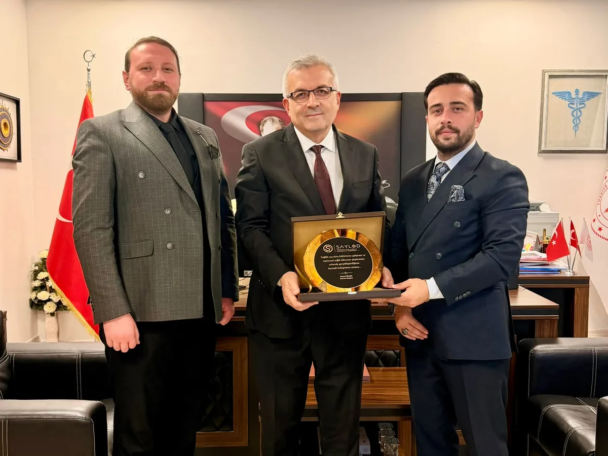 Kocaeli İl Sağlık Müdürü Dr. Yüksel Pehlevan'a makamında SAYLOD plaketi takdim edilirken.