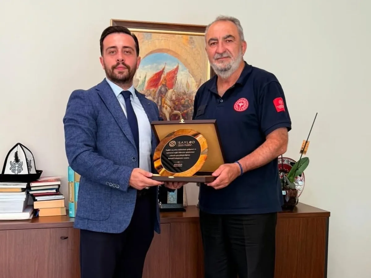 SAYLOD heyeti, Ankara İlaç ve Tıbbi Cihaz Hizmetleri Başkanı Doç. Dr. Ümit Murat Parpucu'ya plaket takdim ederken.